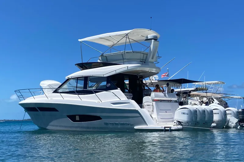 The Image of 2023 Regal 38 FXO yacht on clear blue water, featuring multiple Yamaha engines. - 0