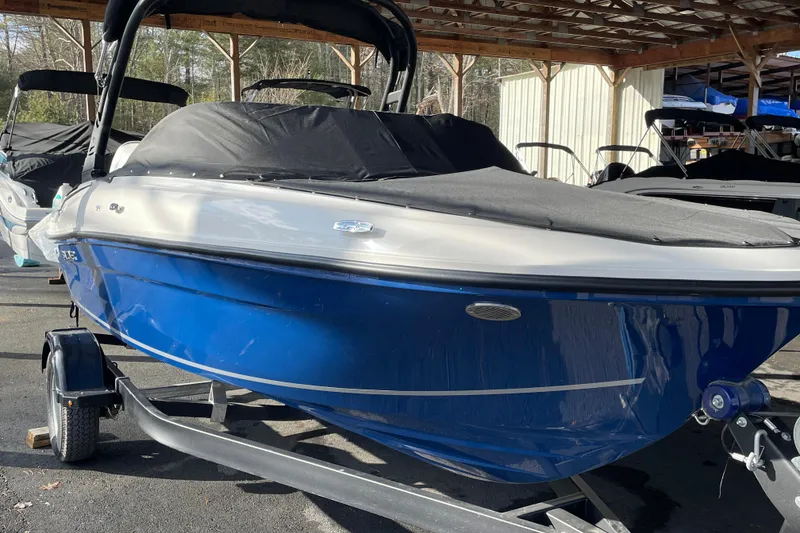 The Image of 2026 Bayliner VR4 Bowrider OB, blue hull, covered, on trailer in storage area. - 0