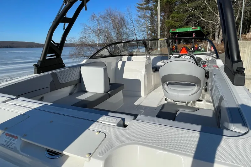 Slide: The Image of 2026 Bayliner VR4 Bowrider OB interior with seating and steering wheel, near a frozen lake. - 18