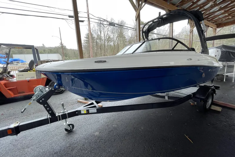 Slide: The Image of 2026 Bayliner VR4 Bowrider OB on trailer, blue and white, under shelter. - 5