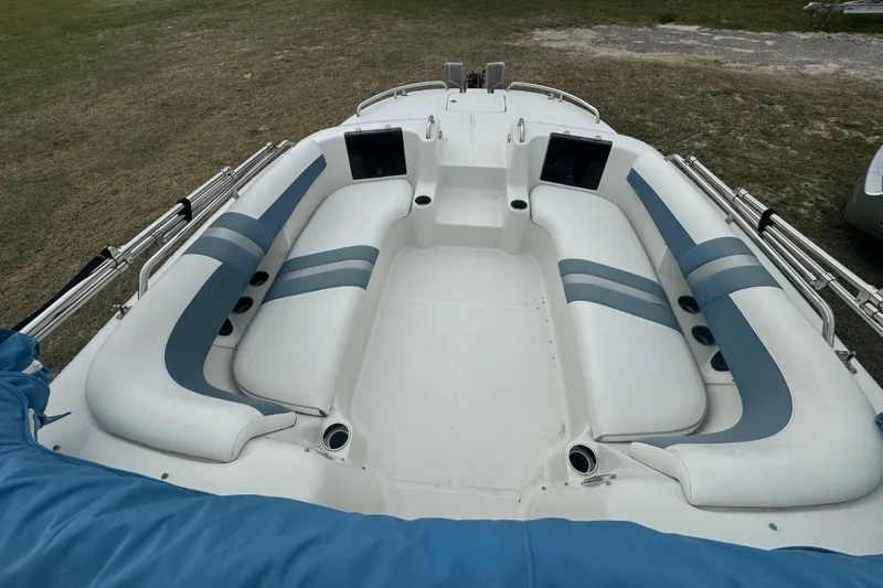 Slide: The Image of 2012 Splendor 259 SUNSTAR boat interior with white and blue seating, docked on grass. - 6
