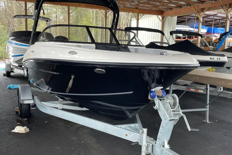 The Image of 2026 Bayliner VR4 Bowrider OB on trailer in covered storage area. - 0