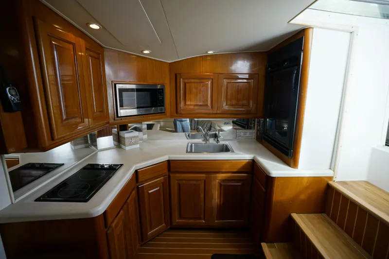 Slide: The Image of 1998 Viking Open Express 43 yacht kitchen with wooden cabinets and modern appliances. - 10