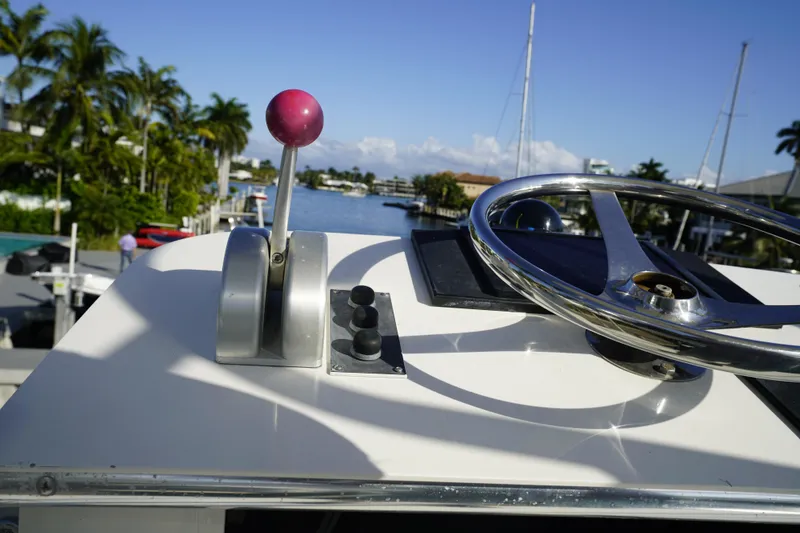 Slide: The Image of Control panel of a 1998 Viking Open Express 43 boat with steering wheel and throttle. - 16