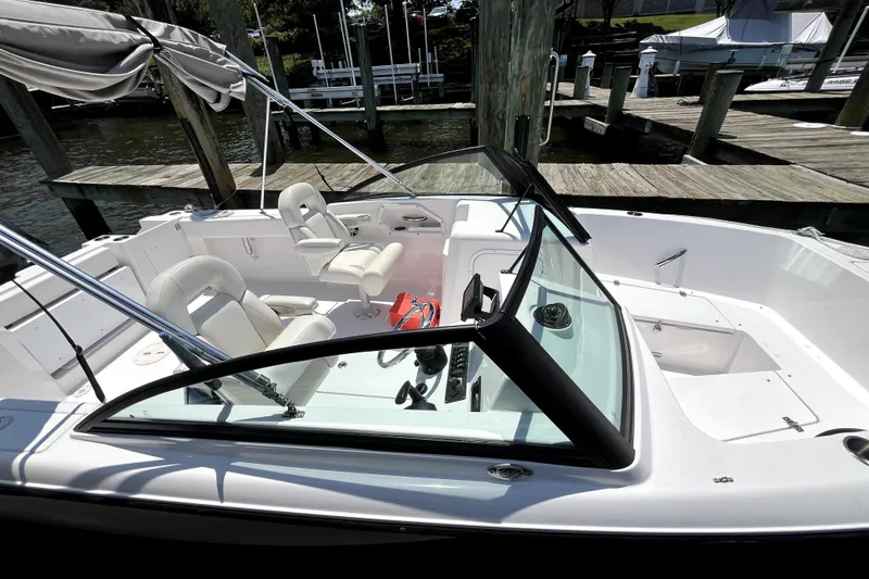 Slide: The Image of 2024 Aquasport 2200 Dual Console boat docked, featuring spacious seating and sleek design. - 3