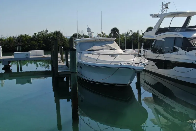 Slide: The Image of 2004 Tiara Yachts 4200 Open docked in a serene marina setting. - 25