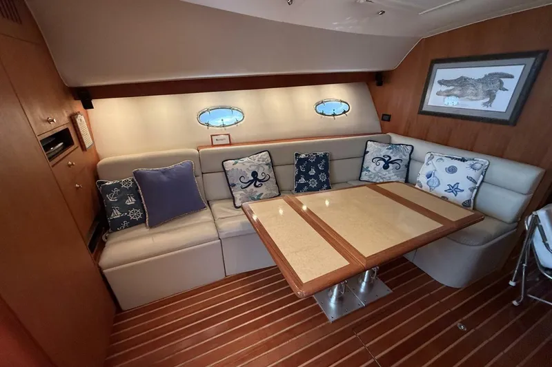 Slide: The Image of Interior of 2004 Tiara Yachts 4200 Open with cozy seating and nautical-themed cushions. - 4