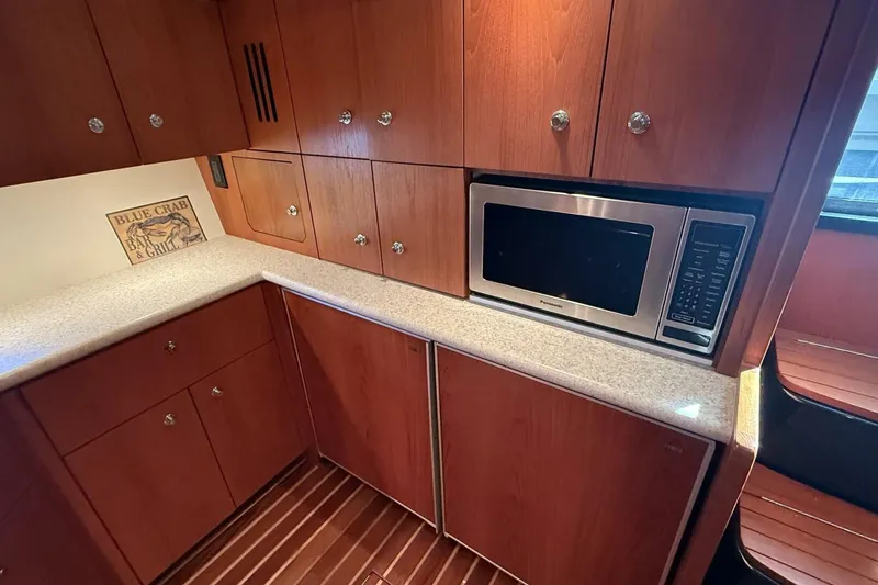 Slide: The Image of 2004 Tiara Yachts 4200 Open galley with wood cabinets and built-in microwave. - 8