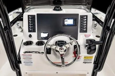 Slide: The Image of 2026 Robalo R222 Center Console boat dashboard with steering wheel and electronic controls. - 9
