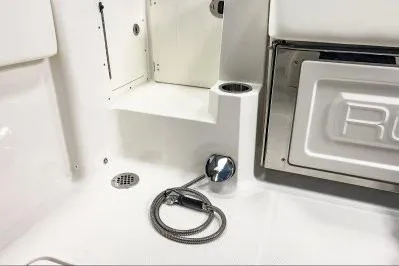 Slide: The Image of 2026 Robalo R270 Center Console boat interior with storage and hose detail. - 15