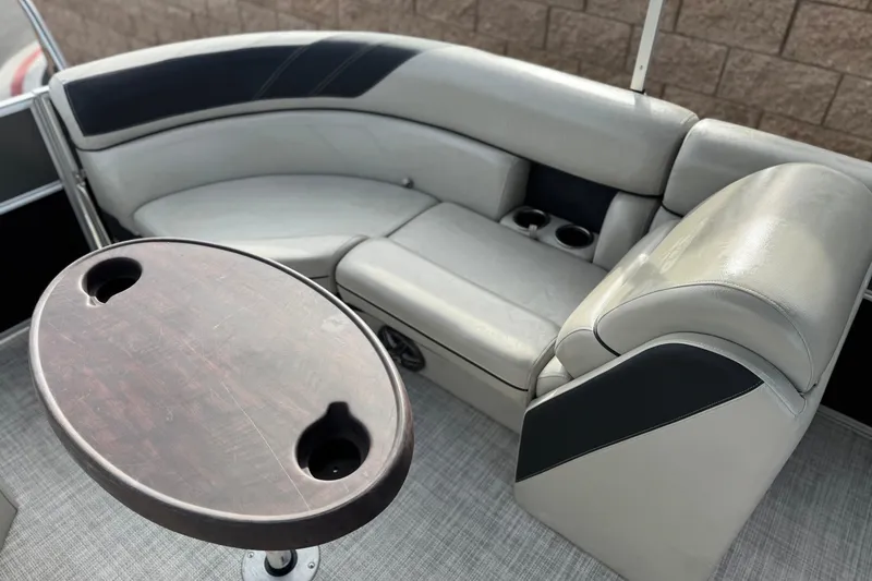 Slide: The Image of 2023 Berkshire 22RFX LE boat interior with gray seating and wooden table. - 18