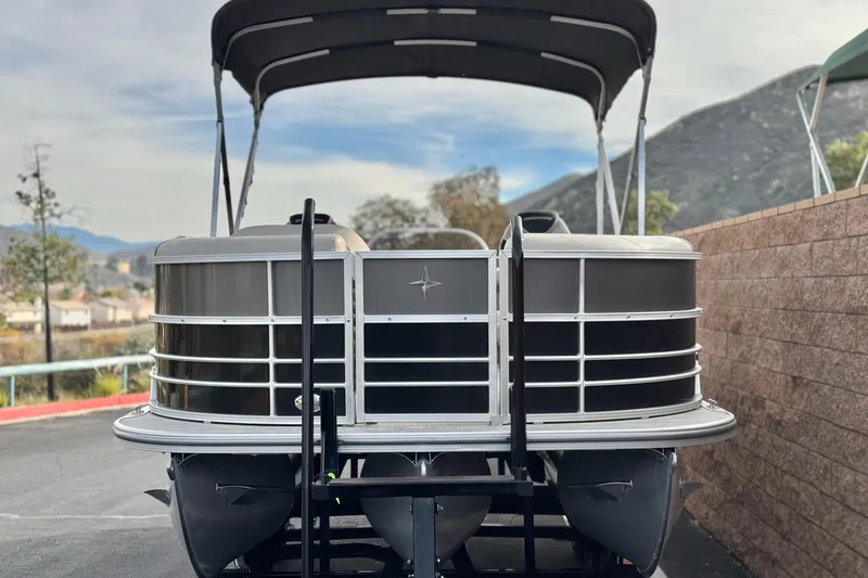 Slide: The Image of 2023 Berkshire 22RFX LE pontoon boat parked with scenic mountain backdrop. - 2