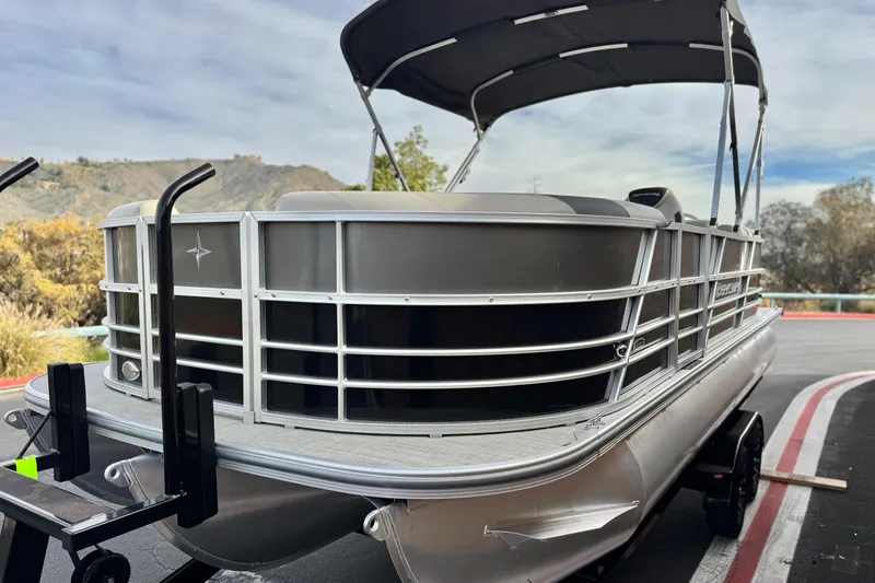 Slide: The Image of 2023 Berkshire 22RFX LE pontoon boat on trailer, scenic background. - 3
