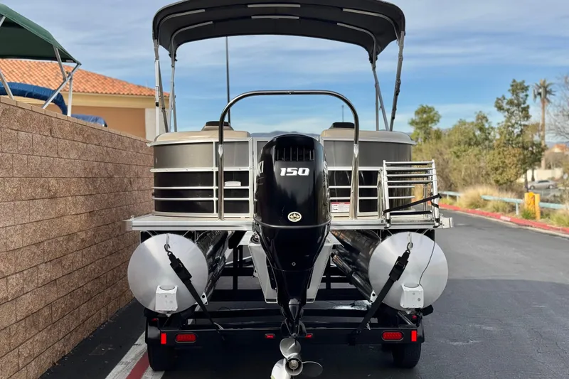 Slide: The Image of 2023 Berkshire 22RFX LE pontoon boat with 150 HP engine, parked outdoors. - 5