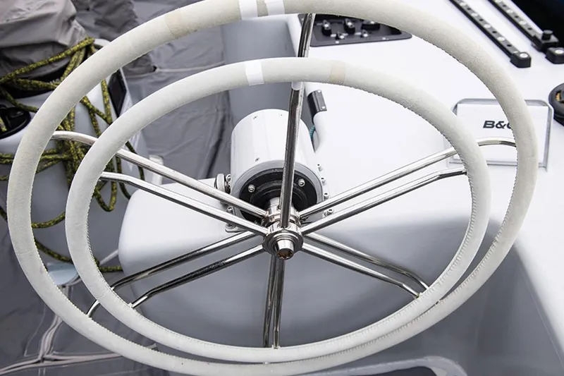 Slide: The Image of Steering wheel of a 1997 Sparkman & Stephens 12M yacht, featuring dual white wheels. - 14
