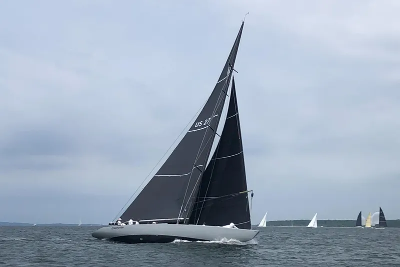 Slide: The Image of Sleek 1997 Sparkman & Stephens 12M sailboat gliding on open water under cloudy skies. - 7