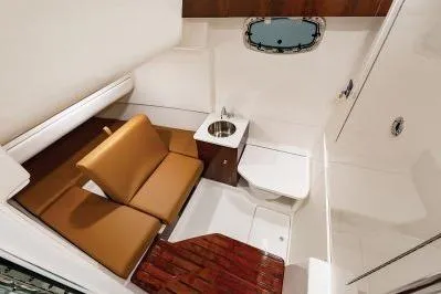 Slide: The Image of 2026 Robalo R360 Center Console cabin with seating, sink, and porthole. - 12