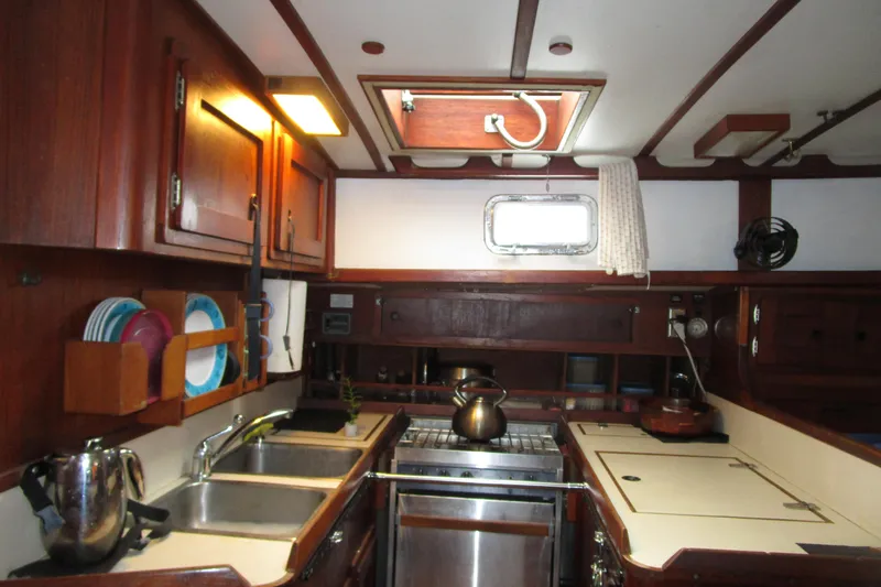 Slide: The Image of 1977 Valiant 40 yacht kitchen with wooden cabinets, stove, and sink. - 18