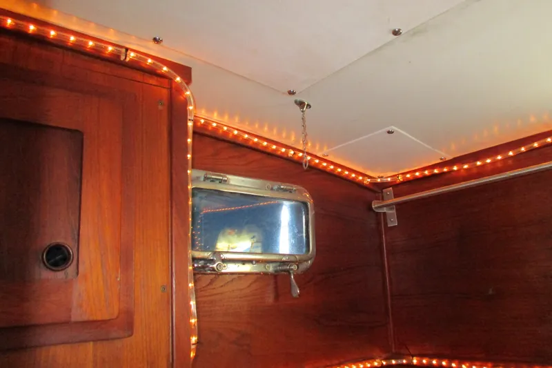 Slide: The Image of Interior of a 1977 Valiant 40 sailboat with wood paneling and ambient lighting port aft. - 19