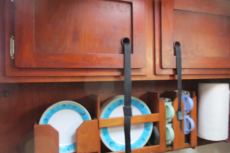 Slide: The Image of Wooden kitchen storage with secured plates and cups on a 1977 Valiant 40 sailboat. - 21