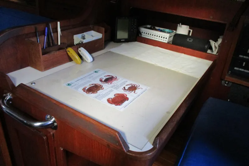 Slide: The Image of Navigation station on a 1977 Valiant 40 sailboat with charts and equipment. - 26