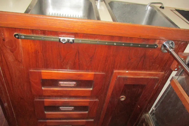 Slide: The Image of Wooden cabinetry with metal rail in a 1977 Valiant 40 boat kitchen. - 48
