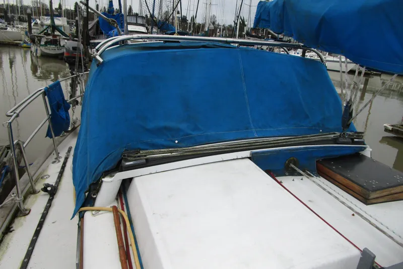 Slide: The Image of 1977 Valiant 40 sailboat with blue canvas cover docked at marina. - 7