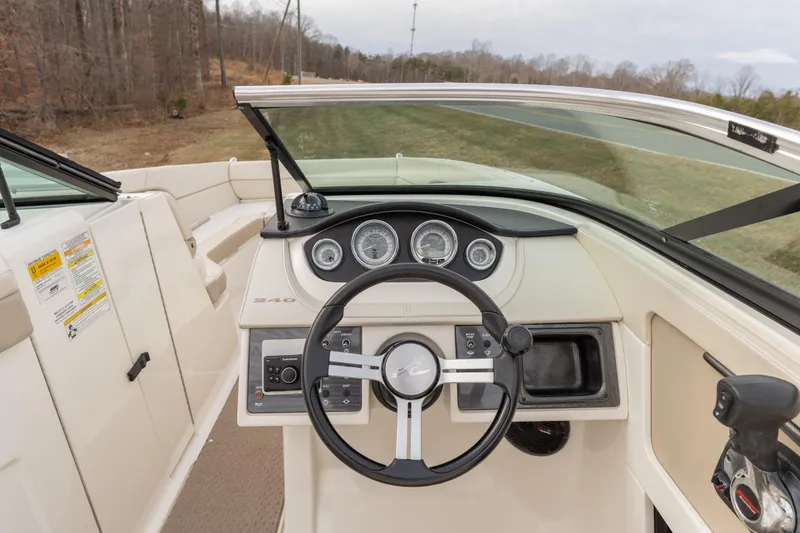 Slide: The Image of 2014 Sea Ray 240 Sundeck Outboard dashboard with steering wheel and gauges. - 10