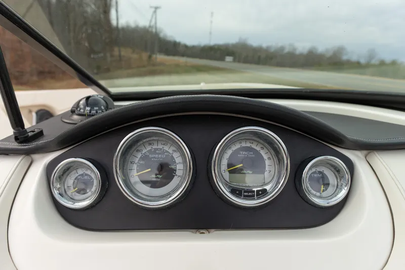 Slide: The Image of Dashboard of a 2014 Sea Ray 240 Sundeck Outboard with gauges and controls. - 11