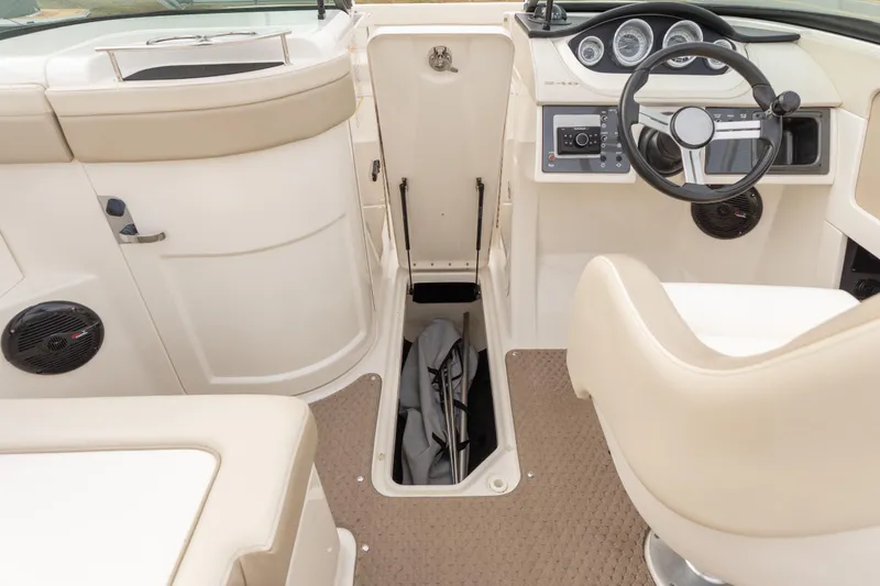 Slide: The Image of 2014 Sea Ray 240 Sundeck Outboard interior with steering wheel and storage compartment. - 18