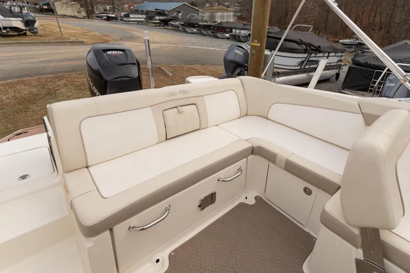 Slide: The Image of 2014 Sea Ray 240 Sundeck Outboard with beige seating and storage compartments. - 19