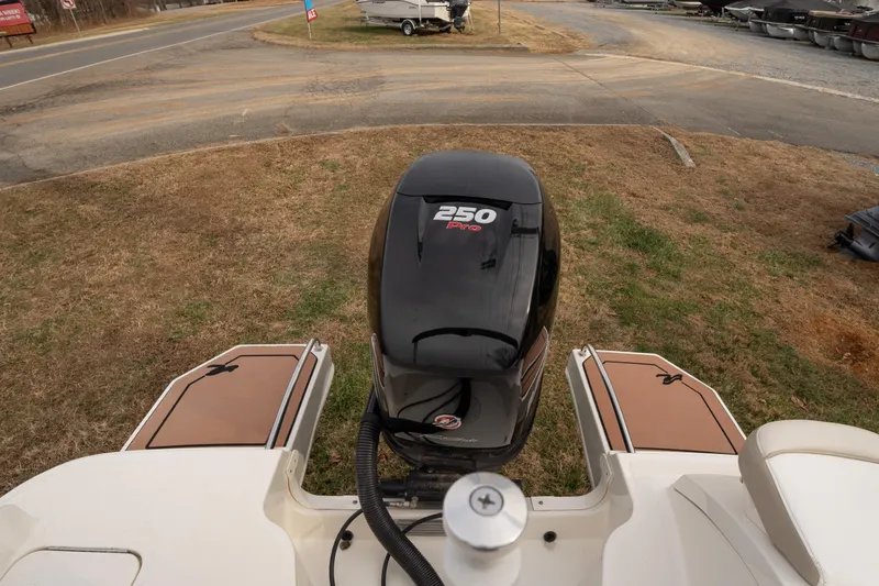 Slide: The Image of 2014 Sea Ray 240 Sundeck Outboard with 250 Pro engine, parked on grass. - 22
