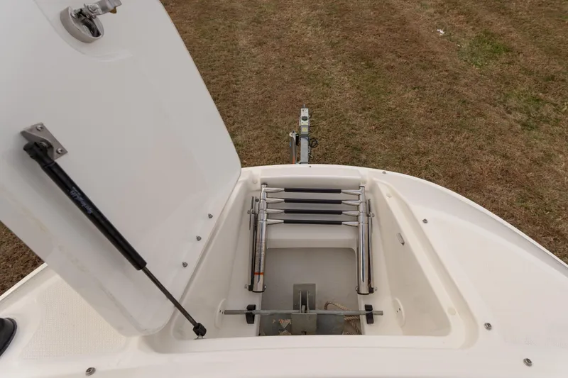 Slide: The Image of Open storage compartment on 2014 Sea Ray 240 Sundeck Outboard boat, showing ladder and latch. - 7