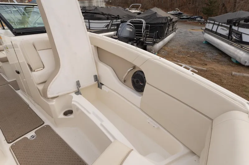 Slide: The Image of 2014 Sea Ray 240 Sundeck Outboard interior with beige seating and speaker system. - 8
