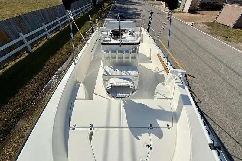 Slide: The Image of 2017 Boston Whaler 210 Montauk boat interior, featuring seating and console, parked on roadside. - 15