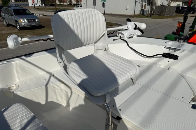 Slide: The Image of 2017 Boston Whaler 210 Montauk boat seat with white upholstery and fishing equipment. - 18