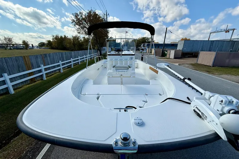 Slide: The Image of 2017 Boston Whaler 210 Montauk boat with canopy, parked on a road under a blue sky. - 6