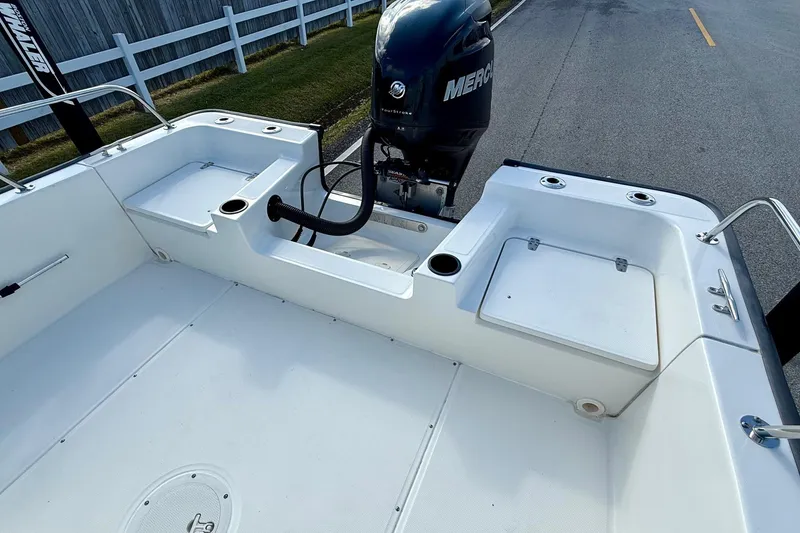 Slide: The Image of 2017 Boston Whaler 210 Montauk boat interior with Mercury engine, white deck, and storage compartments. - 7