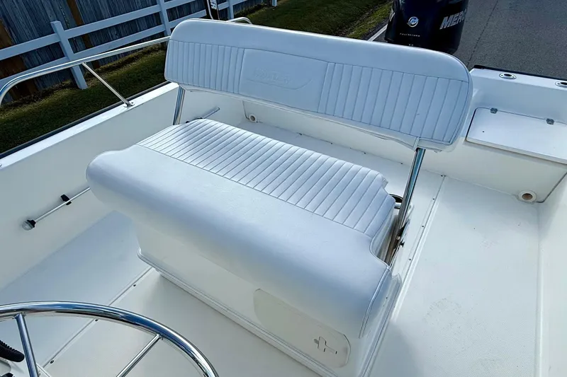 Slide: The Image of 2017 Boston Whaler 210 Montauk boat interior with white cushioned seating. - 9