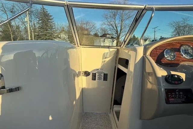 Slide: The Image of 2005 Sea Ray 220 Sundeck cockpit with steering wheel and dashboard, under clear blue sky. - 13