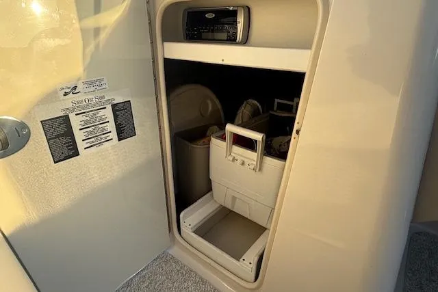 Slide: The Image of 2005 Sea Ray 220 Sundeck storage compartment with stereo and organized gear. - 14