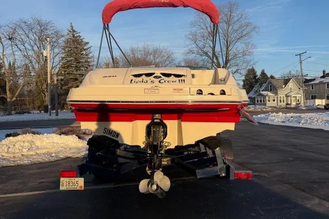 Slide: The Image of 2005 Sea Ray 220 Sundeck boat on trailer with red canopy, parked in snowy driveway. - 2