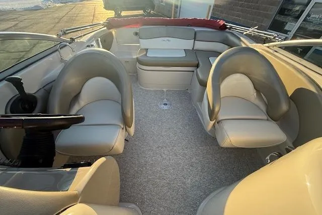 Slide: The Image of 2005 Sea Ray 220 Sundeck interior with beige seating and steering wheel. - 23