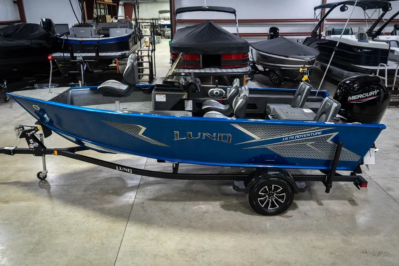 The Image of 2026 Lund 1675 Adventure SS boat in showroom, blue exterior, on trailer. - 0
