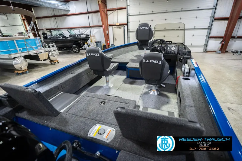 Slide: The Image of 2026 Lund 1675 Adventure SS boat interior with seating and steering wheel in a showroom. - 12