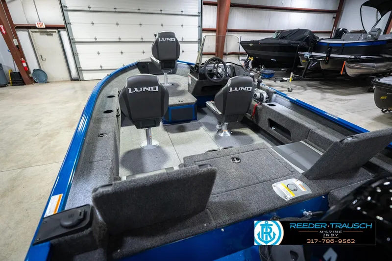 Slide: The Image of 2026 Lund 1675 Adventure SS boat interior with seating and steering wheel in a showroom. - 13