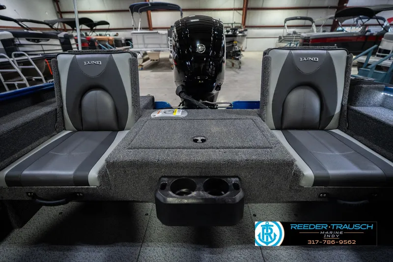 Slide: The Image of 2026 Lund 1675 Adventure SS boat interior with gray seating and motor in showroom. - 19