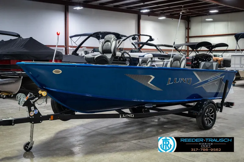 Slide: The Image of 2026 Lund 1675 Adventure SS boat in showroom, blue exterior, on trailer. - 2