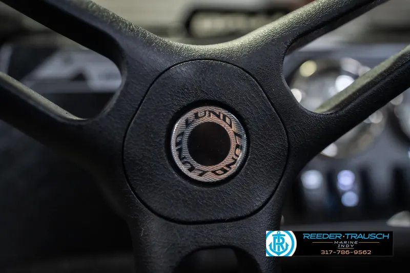 Slide: The Image of Steering wheel of 2026 Lund 1675 Adventure SS boat, featuring logo detail. - 30