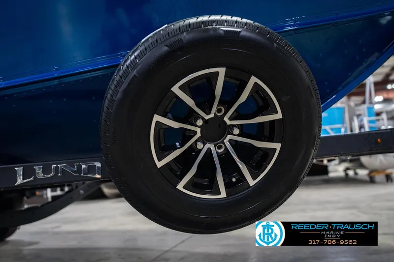 Slide: The Image of 2026 Lund 1675 Adventure SS boat trailer wheel in a showroom setting. - 53